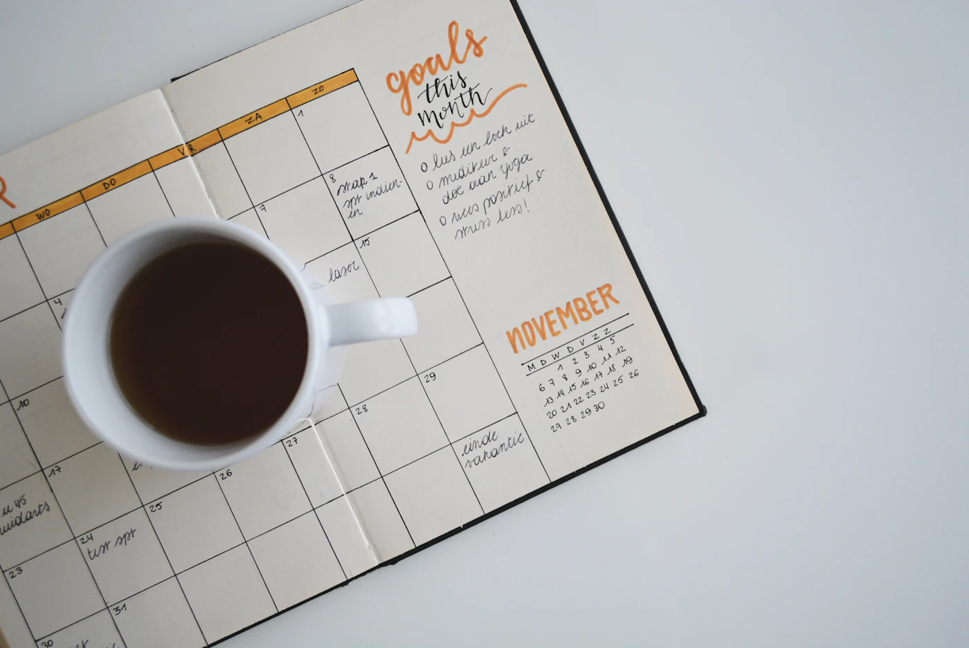 A calm desk with a notebook, coffee cup and warm morning light